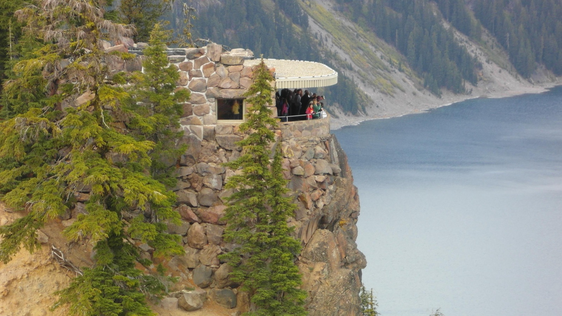 Stone Sinnott Memorial overlook with railing above the blue water of Crater Lake