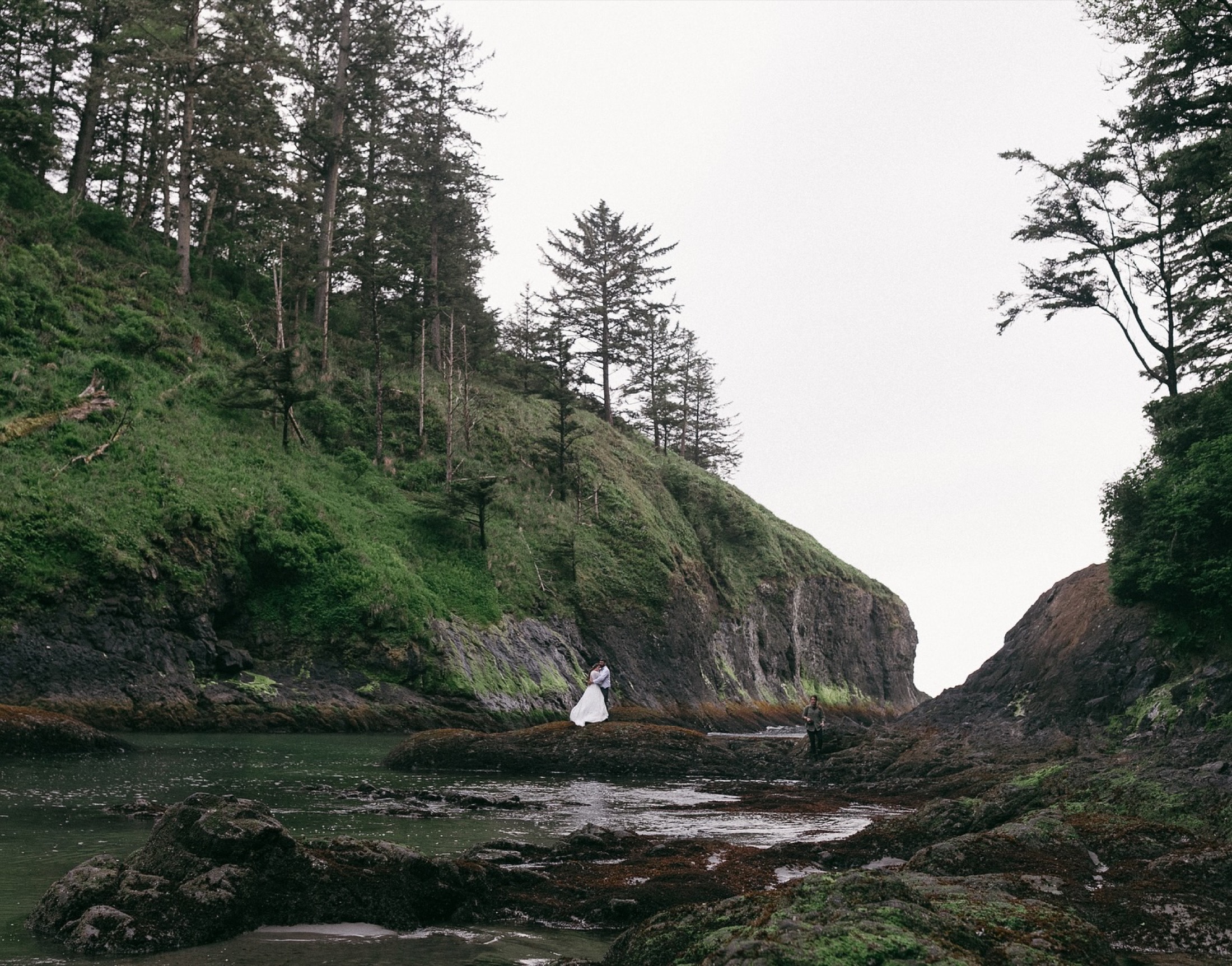 A couple on a quiet coastal cove at low tide with exposed rock