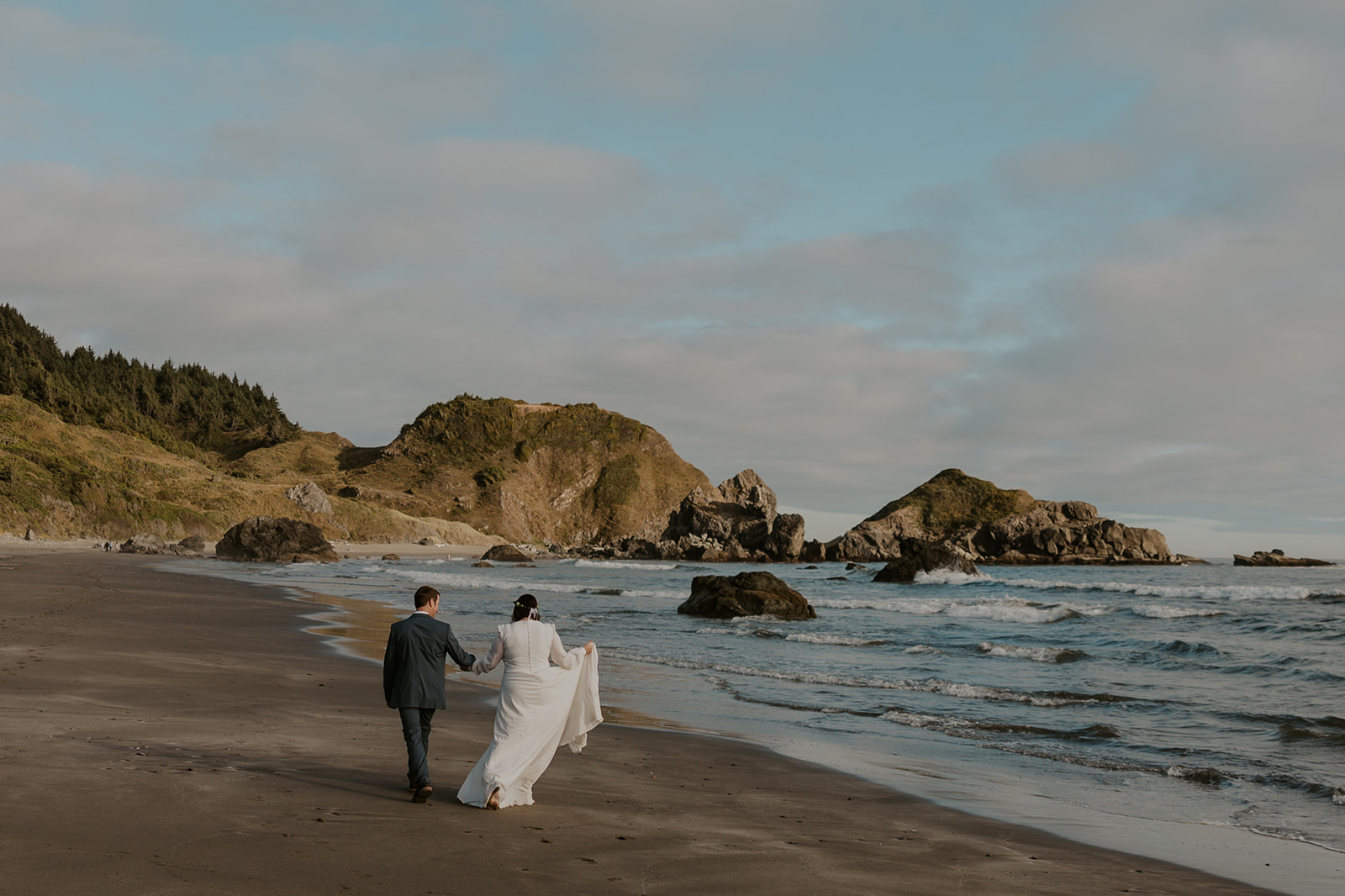 Couple walking the beach at an Oregon coast elopement