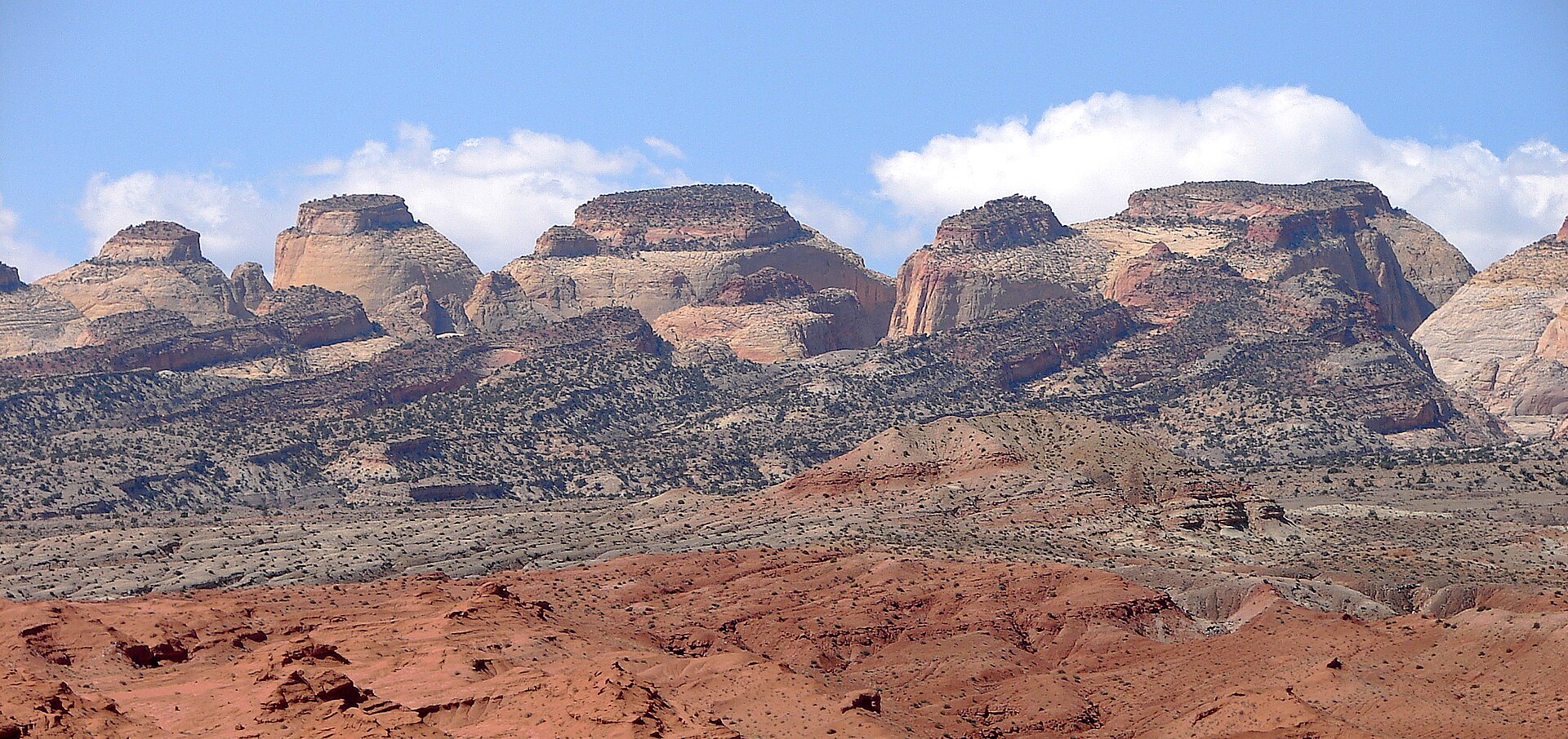Red and white sandstone domes rising over the desert in Capitol Reef National Park, Utah